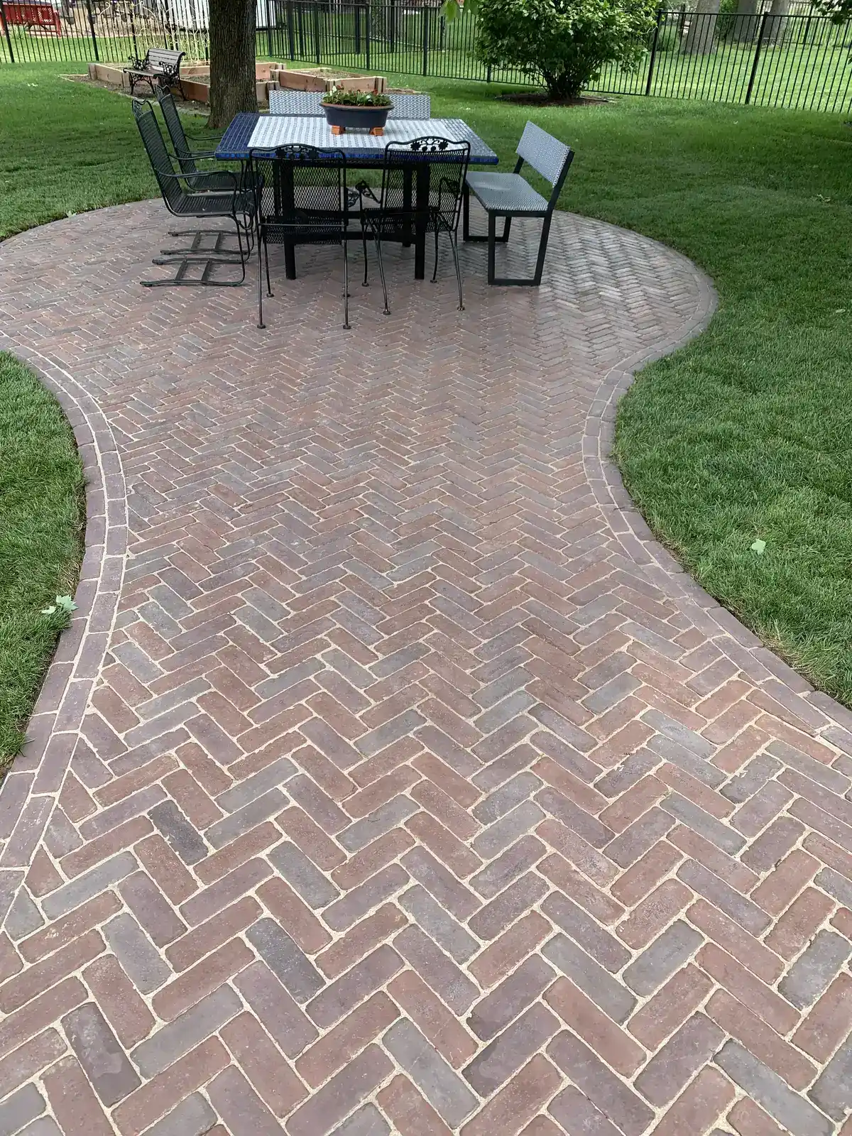 Herringbone brick paver patio with curved border by Green Operations