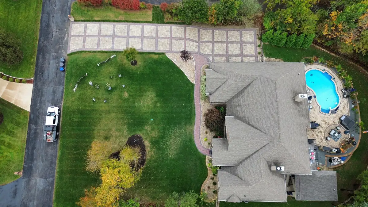 Aerial view of property with custom paver driveway and pool by Green Operations
