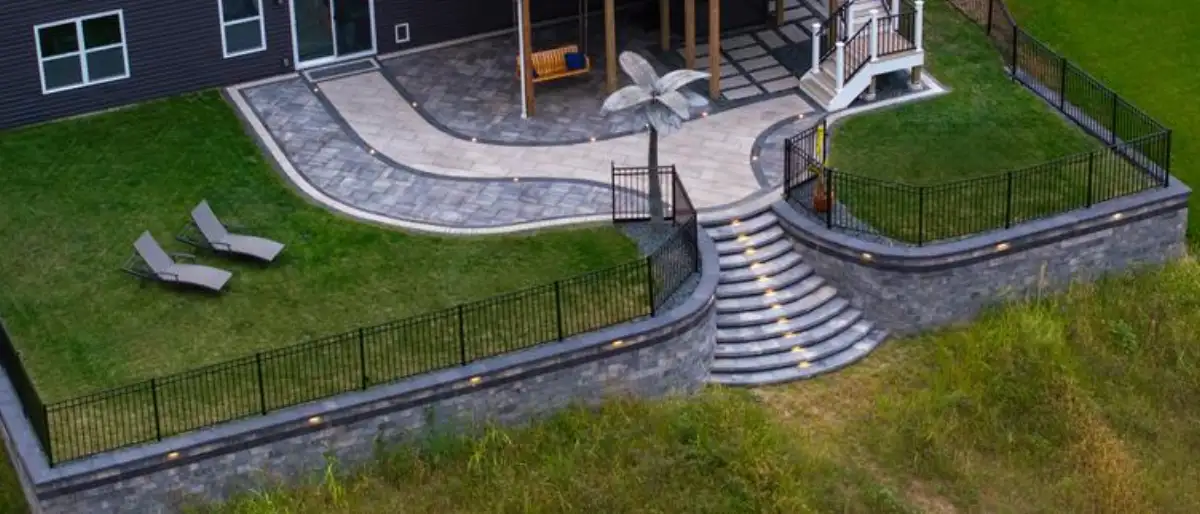Multi-level paver patio with curved steps and landscape lighting in St. Louis