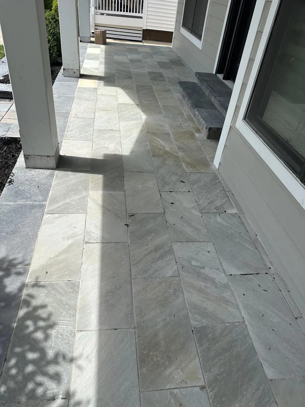 Large-format natural stone walkway through a landscaped entry area