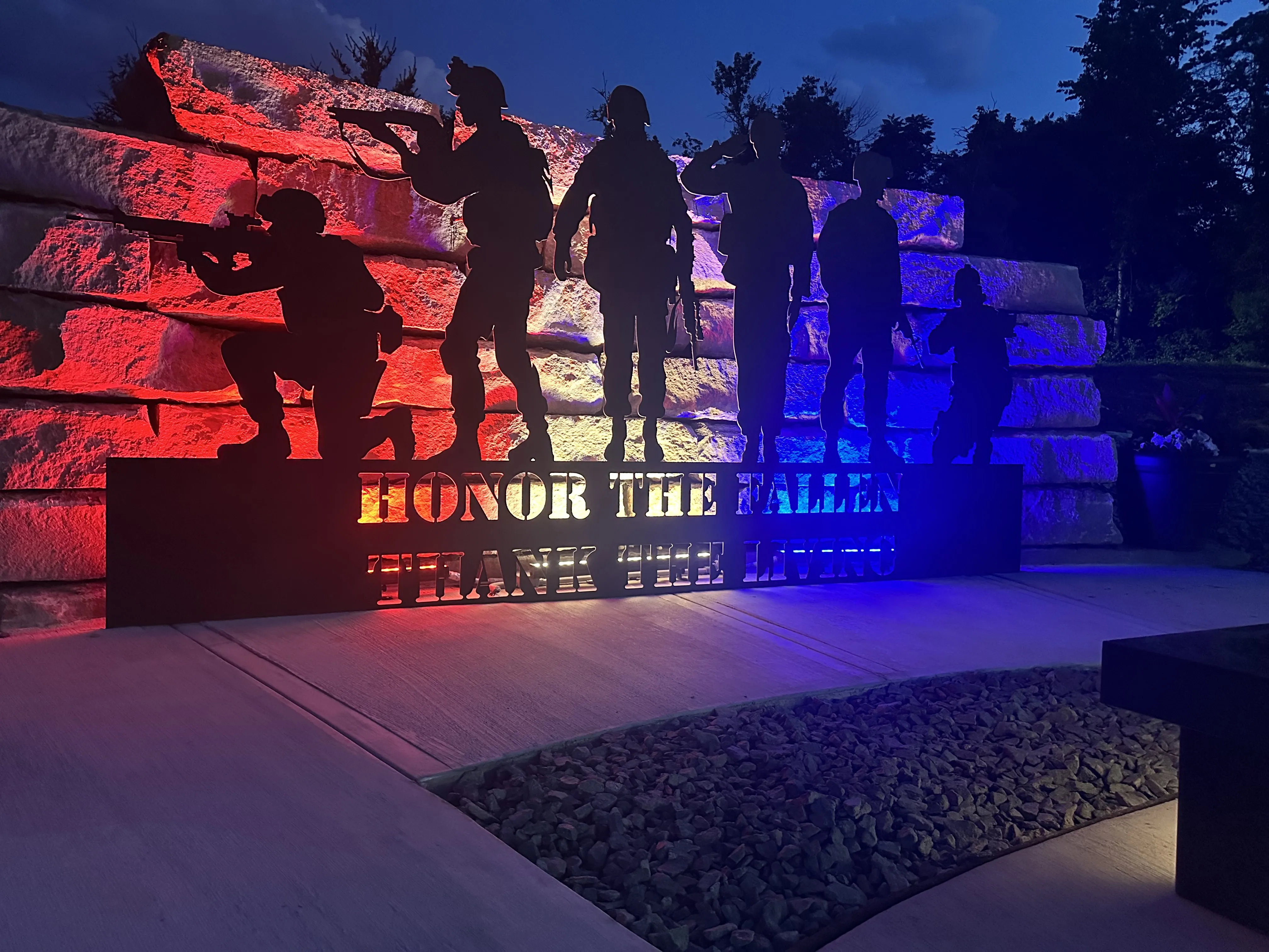 Veterans memorial built by Green Operations, lit with red white and blue lights at night