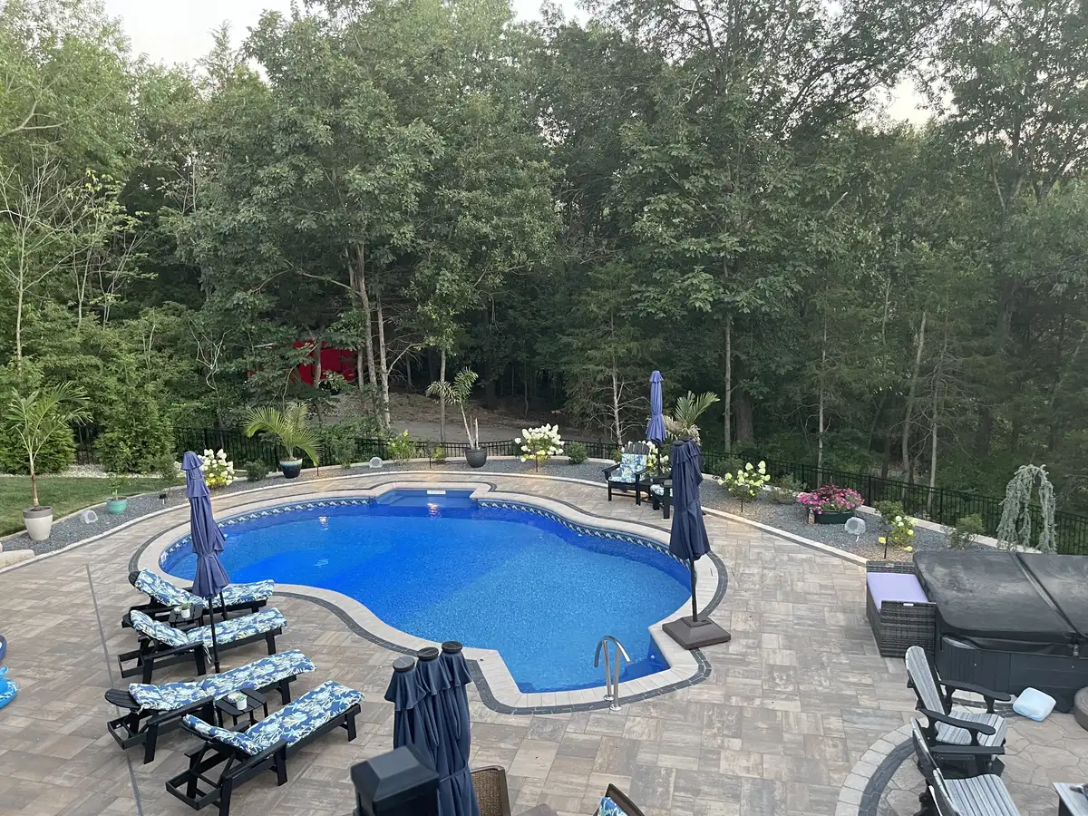Pool with paver deck and lounge chairs in wooded St. Louis backyard