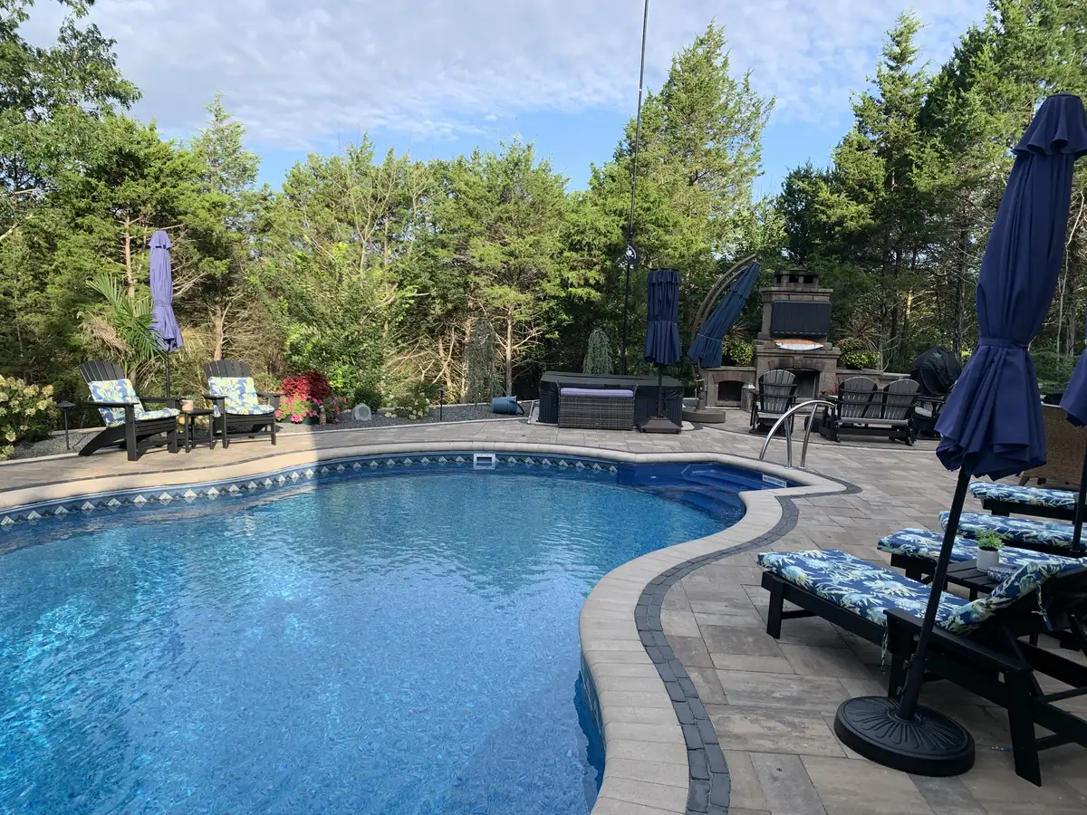 Pool area with outdoor TV, fireplace, and paver deck entertainment space