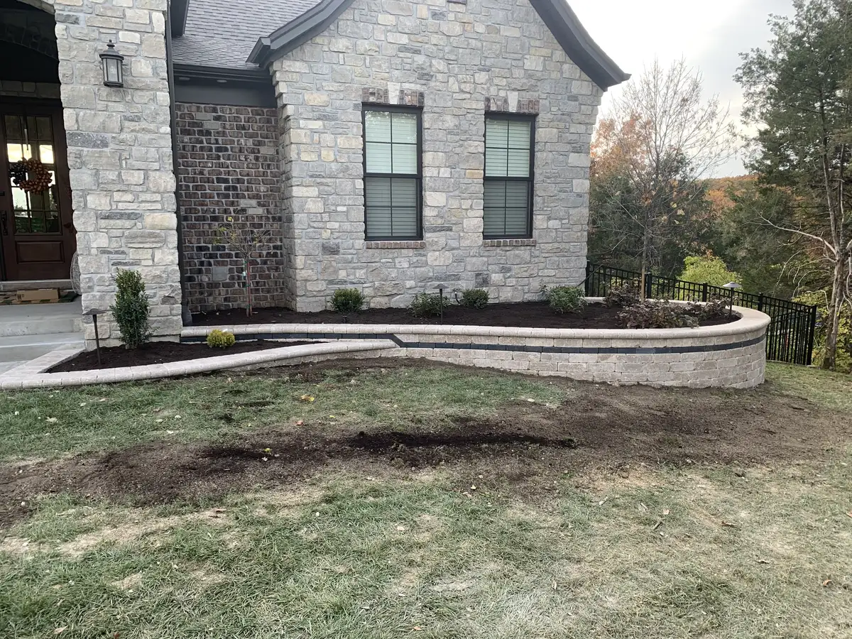 Large structural retaining wall supporting hillside next to house